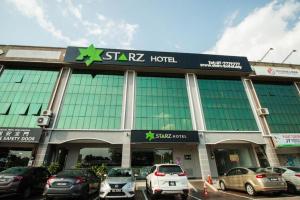 a building with cars parked in front of it at Starz Hotel in Kluang