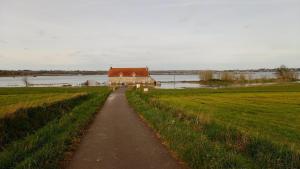 a path leading to a barn in a field at Ploubalay Chambres Cuisine Séjour in Ploubalay