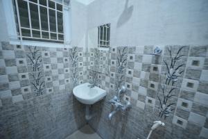 a bathroom with a sink and a window at JR Service Apartment in Coimbatore +11 photos