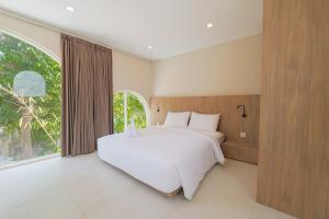 ein Schlafzimmer mit einem großen Bett und einem großen Fenster in der Unterkunft 1BR Stylish Mezzanine Near In Dreamland in Uluwatu