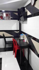 a room with a black table and a red chair at Kota Damansara Business Hotel in Kepong Cubitt Forest Village