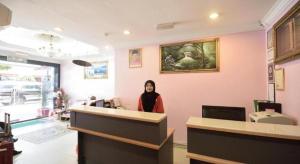 a woman standing behind a counter in a salon at OYO 969 Hotel Pantai View in Labuan