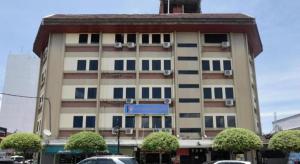 a tall building with cars parked in front of it at OYO 969 Hotel Pantai View in Labuan
