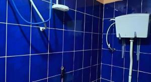 ein blau gefliestes Badezimmer mit einer Dusche mit einer blauen Wand in der Unterkunft New Rawang Hotel in Kuala Lumpur