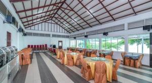 a large room with tables and chairs and windows at Dreamland Beach Holiday in Kudat
