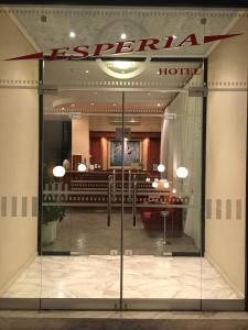 ルートラ・イパティスにあるHotel Esperiaのホテルの看板とガラスドアのあるロビー