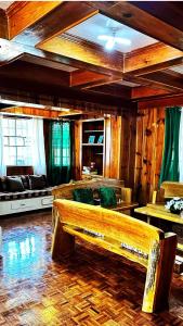 a living room with a bench in the middle of a room at 3 Bedroom House in the Heart of Baguio with Garage in Camp John Hay