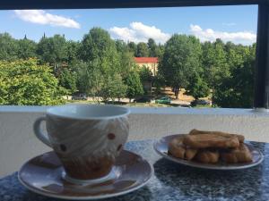 eine Tasse Kaffee und Teller mit Gebäck auf einem Tisch in der Unterkunft Therma Hotel in Loutra Ipatis