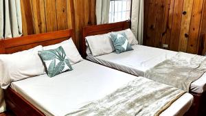 two beds sitting next to each other in a bedroom at 3 Bedroom House in the Heart of Baguio with Garage in Camp John Hay