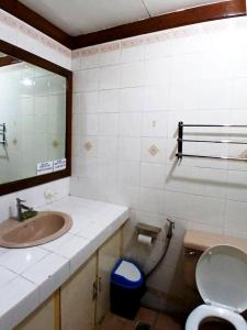 a bathroom with a sink and a toilet and a mirror at 3 Bedroom House in the Heart of Baguio with Garage in Camp John Hay +14 photos