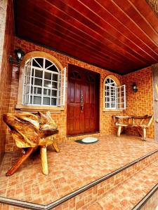 a porch with a wooden door and a bench at 3 Bedroom House in the Heart of Baguio with Garage in Camp John Hay