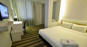 a hotel room with a bed and a flat screen tv at First Residence Hotel Kemaman in Kampong Gong Pauh +3 photos