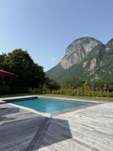 a swimming pool with a mountain in the background at Rôtisserie in Saint-Maurice +16 photos