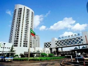 Un alto edificio bianco con una bandiera davanti di The Twenty First Century Hotel a Pechino