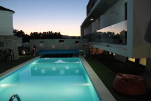 una piscina con iluminación azul junto a un edificio en Casa das Origens, en Campia