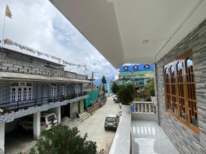 a view from the balcony of a building with a car at Norkyi Homestay in Tawang