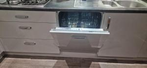 een keuken met een wastafel en een vaatwasser bij Solid Mirror Home Milton Keynes in Bletchley