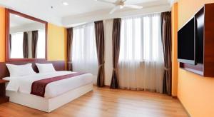 a bedroom with a bed and a flat screen tv at OYO 90636 Teratak Zakiah Chalet in Jerantut