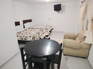 a room with a table and a bed and a chair at Hotel Los Ajolotes in Chignahuapan