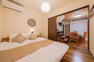 a bedroom with a bed and a dining room at 京都駅前の貸切京町屋 霞秀草庵 庭園と露天風呂で旅の疲れを癒す 3寝室 5ベッド 2バスルーム in Kyoto