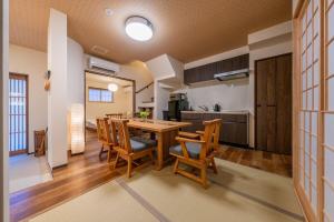 a kitchen and dining room with a table and chairs at 京都駅前の貸切京町屋 霞秀草庵 庭園と露天風呂で旅の疲れを癒す 3寝室 5ベッド 2バスルーム in Kyoto