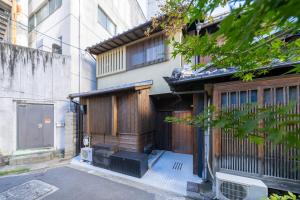 an external view of a building with a gate at 京都駅前の貸切京町屋 霞秀草庵 庭園と露天風呂で旅の疲れを癒す 3寝室 5ベッド 2バスルーム in Kyoto