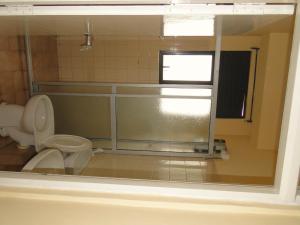 a bathroom with a toilet and a window at BRAMA Station Court  in Colombo