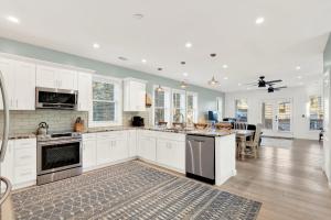a kitchen with white cabinets and a dining room at Coastal Livin' in Tybee Island