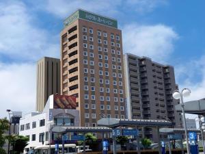 弘前市にあるHotel Route Inn Hirosaki Ekimaeの上に看板がある高い建物