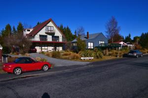 a red car parked in front of a house at Creel House Bed and Breakfast in Lake Tekapo