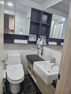 a bathroom with a white toilet and a sink at 여수호텔 퍼스트시티 430호 트윈 하프오션뷰 in Ungch'ŏn-ni