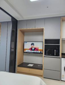 a room with a tv on a wall in a kitchen at 여수호텔 퍼스트시티 430호 트윈 하프오션뷰 in Ungch'ŏn-ni