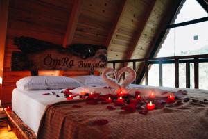 a bed with candles and red roses on it at Ömra bungalov in Dernek +4 photos
