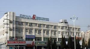 un edificio bianco con un cartello in cima di Jinjiang Inn Yantai Fushan District Fuhai Road a Yantai