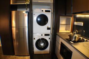 a kitchen with a refrigerator and a washer and dryer at Hospitality Service Suites Scarlitz KLCC in Kuala Lumpur