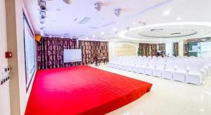 a large room with white chairs and a red carpet at 7 Days Premium Chongqing Fuling Binjiang Avenue Branch in Fuling