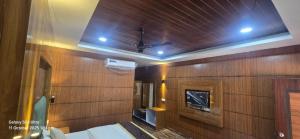 Habitación con paredes revestidas de madera y techo. en Jungle Beach Resort, en Neil Island