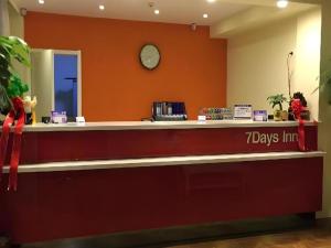 a cash counter with a clock on the wall at 7 Days Inn Hami Baofeng Market in Qumul