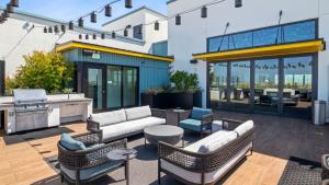 un patio al aire libre con muebles y una parrilla en Aero Apartment, en Alameda