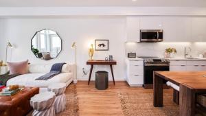 Una sala de estar con un sofá y una cocina. en Aero Apartment, en Alameda