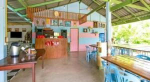ein Zimmer mit Tischen und Stühlen in einem Restaurant in der Unterkunft OYO 1080 Kanyapa Resort Kaeng Krachan in Phetchaburi