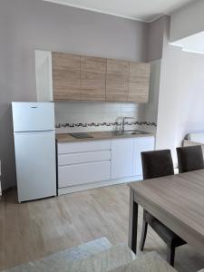 eine Küche mit einem weißen Kühlschrank und einem Tisch in der Unterkunft La Casetta di Nonno Cuono in Acerra