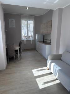 ein Wohnzimmer mit Couch und Küche in der Unterkunft La Casetta di Nonno Cuono in Acerra