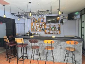 a bar with four stools in a room at Lunar Park Guesthouse in Phumi Ta Phul