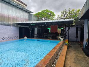 a large swimming pool with a pavilion at Lunar Park Guesthouse in Phumi Ta Phul