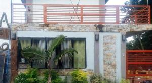 una casa con una palma di fronte a una finestra di RedDoorz @ Balay Hiraya Apartment a Tabao Altre 20 foto