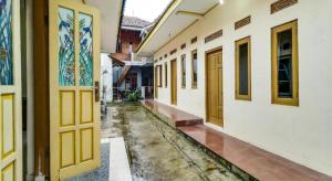 an empty alley with yellow doors in a building at Hotel O My Guest House Syariah in Bandung