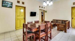 a dining room with a wooden table and chairs at Hotel O My Guest House Syariah in Bandung