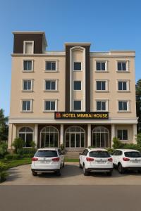 DhārにあるHotel Mumbai House Pithampurのホテルの前に3台の車が停まっています