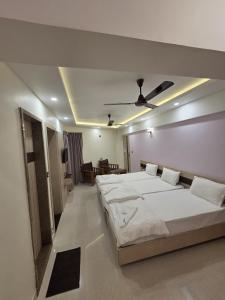 a bedroom with two beds and a ceiling fan at Krishnavasyam lodging in Uppinangadi